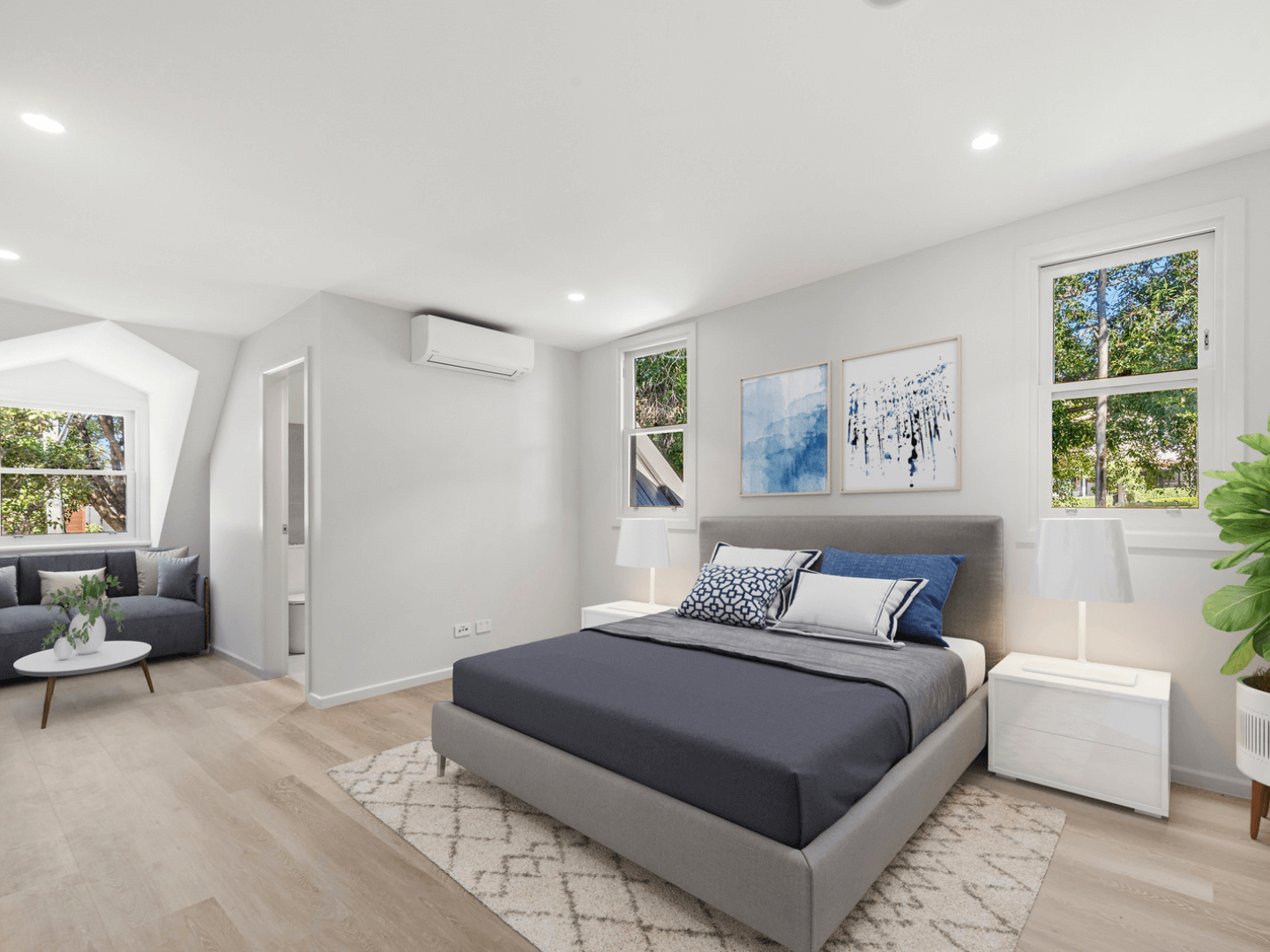 A photograph of a spacious modern bedroom that is beautifully styled
